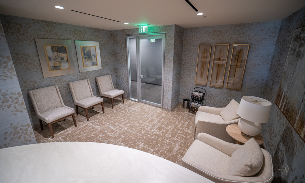 Elegant dental office lobby with neutral upholstered seating, patterned wallpaper, and decorative framed artwork