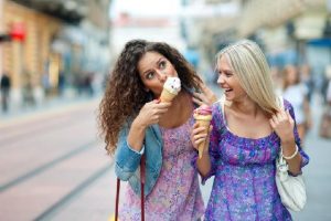Two women comfortably enjoy ice cream thanks to root canal therapy.