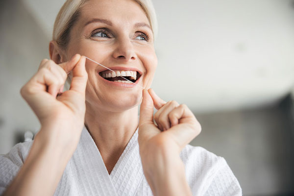 woman flossing her teeth